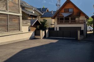 a house with a driveway and a garage at Le JoliCoeur Parking gratuit Idéal cyclistes Proche Alpe d Huez in Le Bourg-dʼOisans