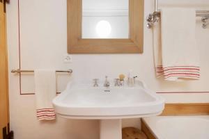 a bathroom with a white sink and a mirror at casa storica nel centro di Bever 4 camere in Bever