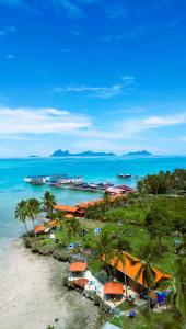 Panglima Resort Semporna في سيمبورنا: منظر جوي لشاطئ مع أشجار النخيل والمحيط