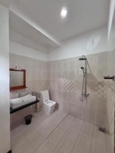 a bathroom with a toilet and a sink and a shower at Sayuru Villa in Hikkaduwa