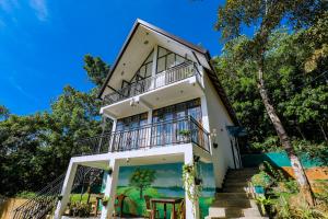 a house with a balcony on top of it at Sunny Hill Villa in Mirissa