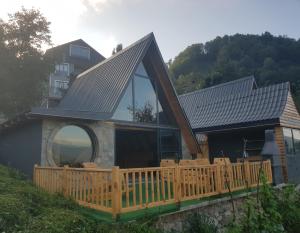 ArdeşenにあるElite Bungalovの大きな窓と木製デッキ付きの家