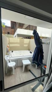 Flat com Hidromassagem Privativa no Centro De Porto de Galinhas - Sol e Mar Residence في بورتو دي غالينهاس: منظر لحمام به حوض استحمام وكرسي