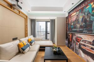 a living room with a couch and a large painting at Yizhimei Apartment Hotel-Guangzhou Huijin International Financial Center Keyun Road Subway STN Branch in Guangzhou
