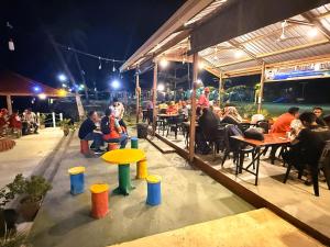 Panglima Resort Semporna في سيمبورنا: مجموعة من الأشخاص يجلسون على الطاولات في مطعم +42 صورة