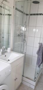 a white bathroom with a shower and a sink at Studio relaxe in Mitry-Mory