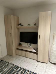 a living room with a flat screen television in a cabinet at Studio relaxe in Mitry-Mory