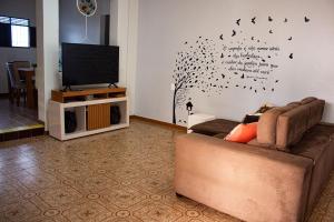 a living room with a couch and a tv at Pousada Aconchego Manaíra in João Pessoa