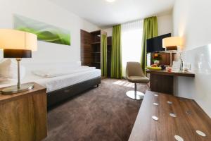 a hotel room with a bed and a desk at Hotel Günter in Lenting