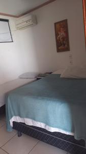 Un dormitorio con una cama con una manta azul. en Pousada na Orla, Atalaia, en Aracaju 3 fotos más