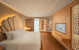 a bedroom with a large bed and a flat screen tv at Anyla Grand Hotels in Thanh Hóa
