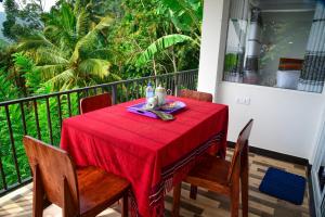 a table with a red table cloth on a balcony at Rokky Hill Cottage Ella in Ella +63 photos