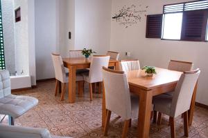 a dining room with wooden tables and white chairs at Pousada Aconchego Manaíra in João Pessoa