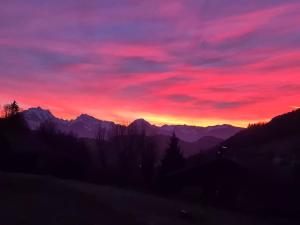 Una puesta de sol en las montañas con un cielo rojo. en La Longeret du Bouchet Mont Charvin, en Le Bouchet-Mont Charvin
