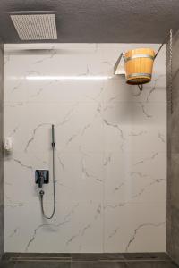 a bathroom with a white marble wall with a shower at TheHouse - Apartment Kamenitza in Velingrad