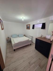 Un dormitorio con una cama y suelo de madera. en La Longeret du Bouchet Mont Charvin, en Le Bouchet-Mont Charvin