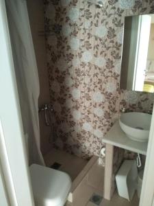 um banheiro com vaso sanitário e pia em Corner Studios em Perea mais 1 fotografia