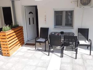 um pátio com 3 cadeiras, uma mesa e uma porta em Corner Studios em Perea