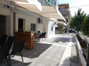 un patio al aire libre con sillas y sombrilla en Corner Studios, en Perea