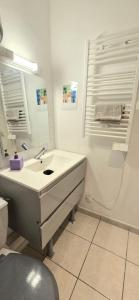a white bathroom with a sink and a mirror at La Proue T2 étoilé in Saint-Méloir-des-Ondes