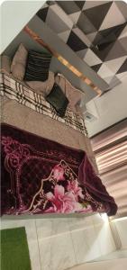 a bed with pillows and a blanket on it at Stodio apartment Noida greater Noida in Ghaziabad