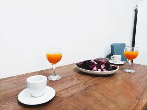 een tafel met twee glazen sinaasappelsap en een bord eten bij OINO APARTMENT in Corfu-stad