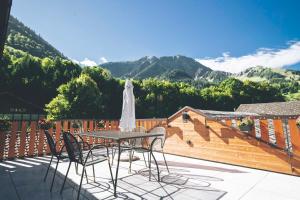 Appartement Cosy & Calme au Cœur de la Gruyère في Jaun: طاولة وكراسي على شرفة مع الجبال +7 صور