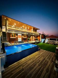 a large house with a swimming pool in front of it at Laalkunj villa in Pune