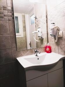 een badkamer met een wastafel en een spiegel bij OINO APARTMENT in Corfu-stad +23 foto's
