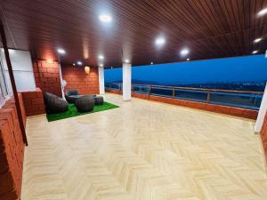 a large room with a balcony with a view of the ocean at Laalkunj villa in Pune