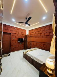 a room with a bed and a brick wall at Laalkunj villa in Pune
