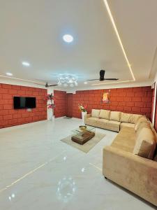 a large living room with a couch and a tv at Laalkunj villa in Pune