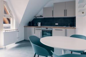cocina con mesa blanca y sillas azules en Moderne 2 Zimmer Wohnung im Herzen von Karlsruhe 64m2 2 OG, en Karlsruhe