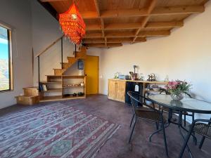 Una sala de estar con una mesa y una escalera. en Santuario Hexágono Mamalluca, en Vicuña