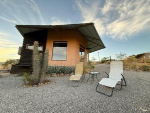una casa con tres sillas y una mesa frente a ella en Santuario Hexágono Mamalluca, en Vicuña