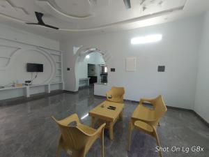 ein Wohnzimmer mit Stühlen und einem Tisch und einem Fernseher in der Unterkunft The Joie Luxury in Puducherry + 12 Fotos