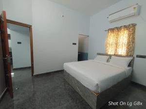 Un dormitorio con una cama blanca y un espejo. en The Joie Luxury, en Pondicherry