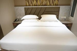 Una cama blanca grande con dos almohadas encima. en The Joie Luxury, en Pondicherry