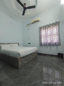 Un dormitorio con una cama con ventilador de techo. en The Joie Luxury, en Pondicherry