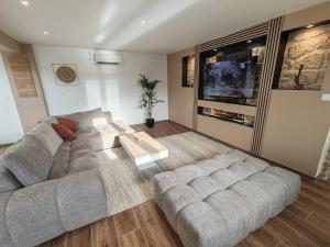 a living room with a couch and a table at Longère de charme rénovée - dépaysement et verdure in Brancourt-en-Laonnois