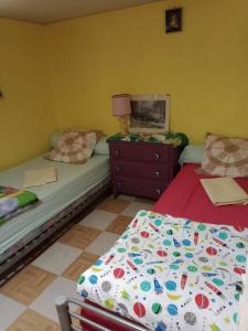 a bedroom with two beds and a dresser with a lamp at Maison entière avec parking, garage et jardin in Montluçon +35 photos