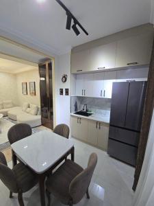 una cucina e un soggiorno con tavolo e sedie di Prestige Apartament a Tashkent