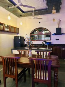 a kitchen with a wooden table and two chairs at Chique Shanti Villa in Mandrem