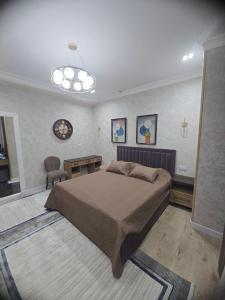 una camera con letto, tavolo e lampadario a braccio di Prestige Apartament a Tashkent