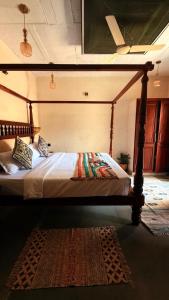 a bed with a wooden frame in a room at Chique Shanti Villa in Mandrem