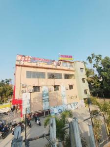 a building with a sign on the top of it at Trishan Hotel in Dhupguri