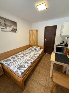 a bedroom with a bed and a table in it at Pokoje gościnne Kozica in Zakopane