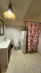 Un baño con inodoro y cortina de ducha en Gypsy Surf Maroc Hostel, en Tamraght Ouzdar