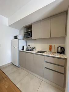 a kitchen with white cabinets and a white refrigerator at Apartamento para 2 personas in Buenos Aires