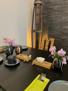a black table with plates and vases with flowers on it at Steinfelderhof in Kröv